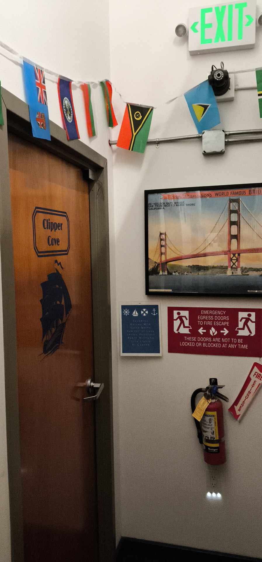 Εσωτερικό του Pacific Tradewinds Hostel με σημαίες και αφίσα της Golden Gate Bridge